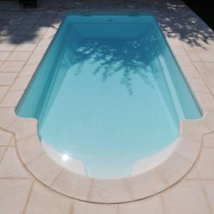 Piscine coque polyester avec fond incliné et escalier roman modèle Tahiti